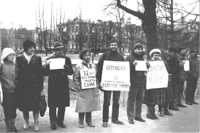 Демонстрация отказников у&nbsp;въезда на&nbsp;территорию зданий обкома и&nbsp;горкома КПСС
(бывший Смольный Институт).
23&nbsp;Апреля 1987, Ленинград.
Слева направо:
1. Елена Кейс 2. Лиля Шапиро 3. Владимир Кнох 4. Римма Сосна 5. Борис Локшин
6. Марк Будняцкий 7. ? 8. Елена Долганова 9. Виктор Долганов 10. Евгений Лейн 11. ? .
Всего в&nbsp;демонстрации приняло участие 23 человека.
(Из&nbsp;фонда Владимира Лифшица)