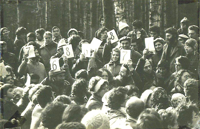 3‑й фестиваль еврейской песни, 1980&nbsp;г., другая часть поляны.
На&nbsp;бревне сидят члены жюри, оценивая уровень исполнения по&nbsp;десятибалльной системе. Слева направо: Мика Членов&nbsp;&mdash; держит оценку 7; Натан Шварцман&nbsp;&mdash; с&nbsp;оценкой 7; Зеэв Престин&nbsp;&mdash; с&nbsp;оценкой 6; Лена Чернобыльская&nbsp;&mdash; держит 8; Наташа Розенштейн&nbsp;&mdash; держит чистый лист; Элиягу Эссас&nbsp;&mdash; 7; Арон Гуревич&nbsp;&mdash; 8; Паша Абрамович&nbsp;&mdash; 7. Рядом с&nbsp;Пашей стоит отказник Саша Этерман, нынешний экономический обозреватель радиостанции на&nbsp;русском языке. Девушка в&nbsp;очках справа от&nbsp;Саши&nbsp;&mdash; отказница Хана Магарик.